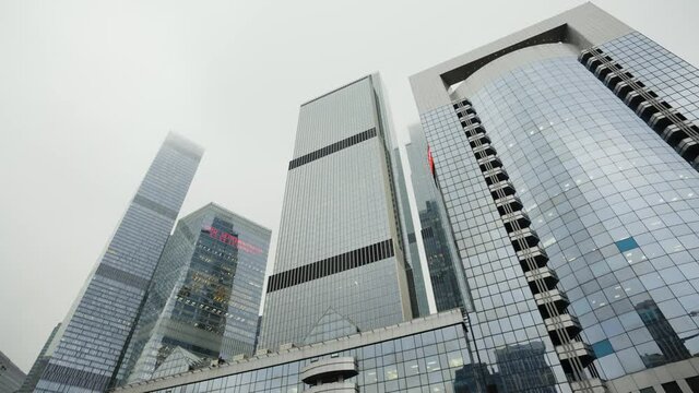 Bottom view of various international business centers, modern architecture. Action. Skyscrapers in Financial District of a big city on heavy sky background.