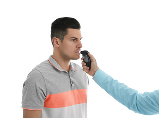 Inspector conducting alcohol breathe testing, man blowing into breathalyzer on white background