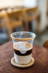 Dirty Coffee - A plastic glass of espresso shot mixed with cold fresh milk in coffee shop cafe and restaurant
