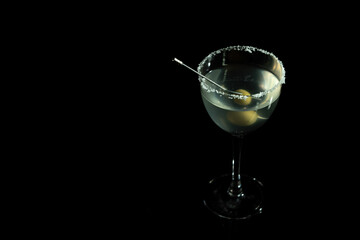 Luxury cocktail glass on black background. High end beverage in bar.