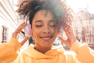 Beautiful black woman with afro curls hairstyle.Smiling model in yellow hoodie.Sexy carefree female...