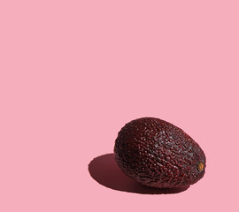  one avoado lies on a pink background 