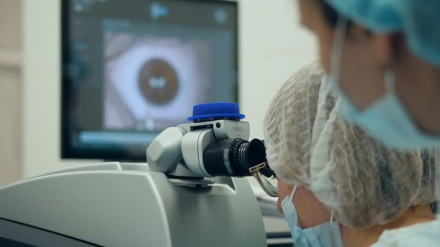 Medical workers are observing eye surgery through the oculars