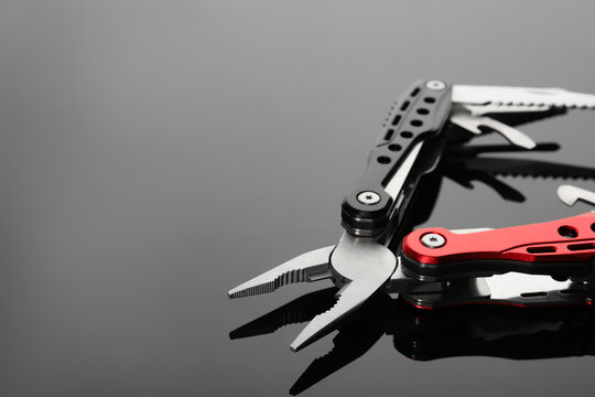 Compact portable multitool on grey table, closeup. Space for text