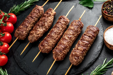 grilled Lula kebab on skewers with spices on a stone background