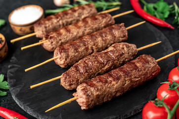 grilled Lula kebab on skewers with spices on a stone background