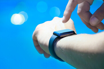 image of watch hand swimming pool background 