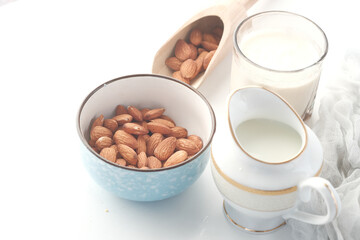  almond nut in bowl and milk on white background 