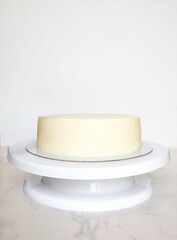 white cake without decor on a stand with copy space
