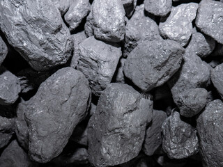 Macro of carbon stones piled up for their subsequent combustion forming an energetic background of this precious mineral used in homes for combustion and producing heat energy to heat the home