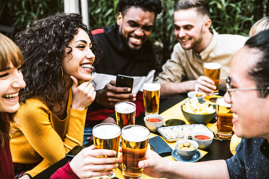 Happy diverse friends drinking beer at brewery pub - Group of young people having fun together at backyard home party - Friendship concept