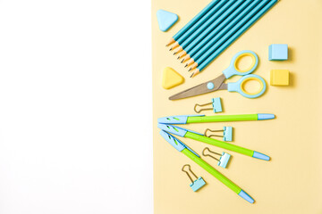 school tools on blue and yellow background top view knolling. back to school, school supplies - pencils and paints, ruler and eraser, paper clips and scissors, notepads and notebooks