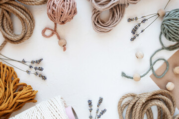 Beautiful layout of materials for macrame: cotton cords, jute twine, wooden beads. Flat lay.