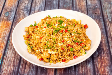 Yellow chaufa rice with chopped fried chicken, pieces of scrambled eggs, bell pepper and vegetables