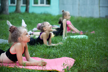 Naklejka premium Girls gymnasts listening to somebody on training outdoors in summer