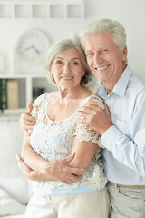 cheerful senior couple embracing at home