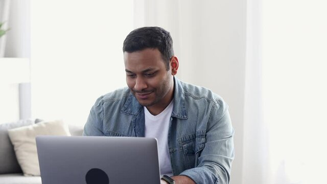 Young Indian businessman in casual clothes finished writing a business plan for a new startup and is dancing with joy, happy student happy that he finished writing his dissertation