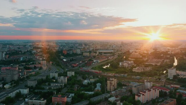 Aerial time lapse hyperlapse big city during sunset, evening cityscape. Drone flight over industrial landscape. Bright sun beams on horizon. Belarus, Minsk panorama overlooking city skyline