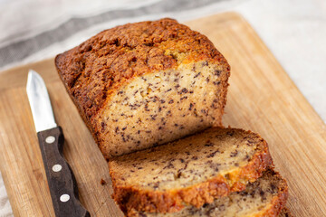 Sliced loaf of banana bread cupcake with poppy seeds on cooling wrack