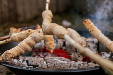 Bread is baked on a stick over the campfire