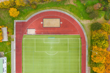 Looking straight down on one half of an empty soccer field with a cinder track 
