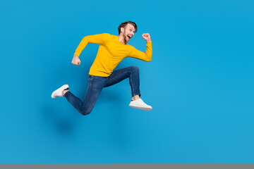 Full length side profile body size of young guy jumping high running on sale isolated vivid blue color background