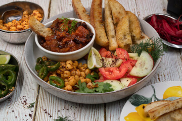 Vegan Middle Eastern bowl consisting of eggplant dip, spicy chickpeas, pita slices and salad