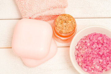 Pink spa salt in a bowl and soap with towels