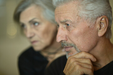 Portrait of sad senior couple posing at home