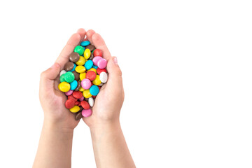 round colored candies in children's hands isolated on a white background. Copy space.