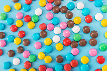 round colored candies on a blue background.