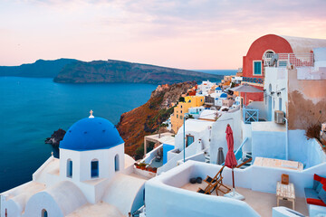 Famous view from viewpoint of Santorini Oia village with blue dome of greek orthodox Christian church