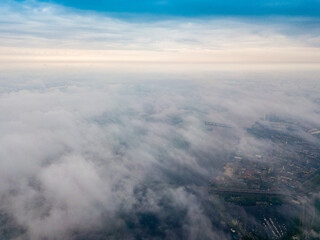 Fototapeta na wymiar High flight above the clouds in Kiev. Spring cloudy morning. Aerial high view.