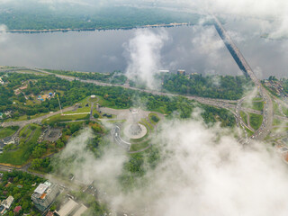 Fototapeta na wymiar High view of the Dnieper River in Kiev through the clouds. Spring cloudy morning. Aerial high view.