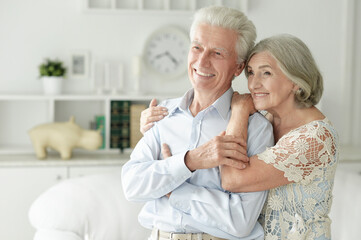 Obraz premium cheerful senior couple embracing at home
