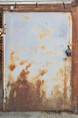 Grungy rusty textured metal door with padlock