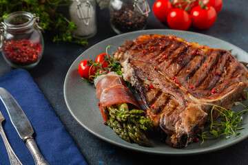 Grilled, medium-baked t-bone beef steak. Served with asparagus.