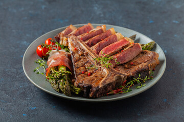 Grilled, medium-baked t-bone beef steak. Served with asparagus.