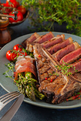 Grilled, medium-baked t-bone beef steak. Served with asparagus.