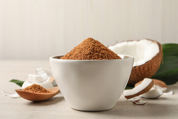Natural coconut sugar in bowl on white wooden table
