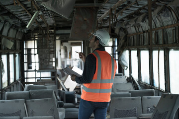 Fototapeta premium man in a train. Workers are checking for damage for renovation train passenger containers. 