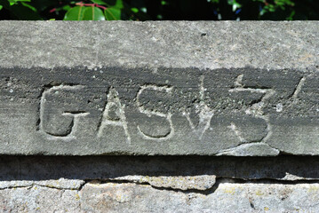 Old Gas Utility Sign Carved into Stone Coping  on Wall