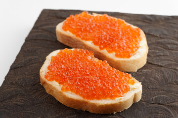 Naklejka na ściany i meble Two loaves of bread with red salmon roe