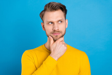 Photo of young handsome man hand touch chin think look empty space isolated over blue color background