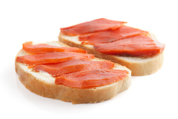 Sandwiches with smoked trout on white surface with shadow