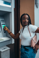 African american woman using credit card and withdrawing cash at the ATM