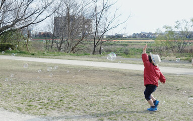 A child chasing a soap bubble.