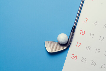 golf ball , golf club and calendar on blue background