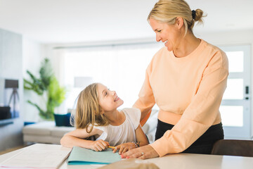 Obraz na płótnie Canvas Mom helping kid with homework at home