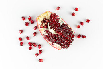 pomegranate slice on a white background with scattered grains